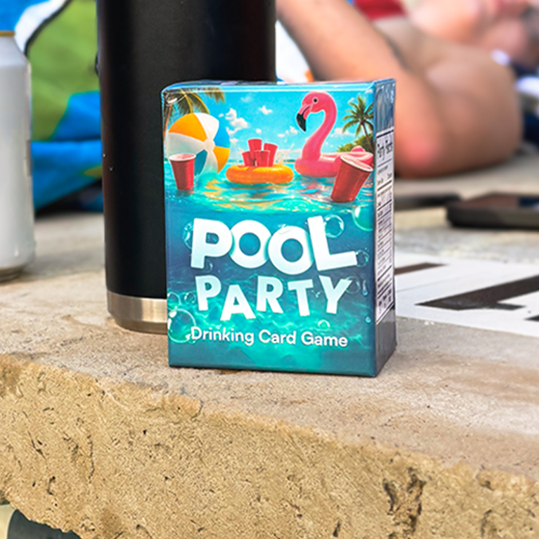 Box of 'Pool Party' drinking card game with pool-themed design on a concrete surface.